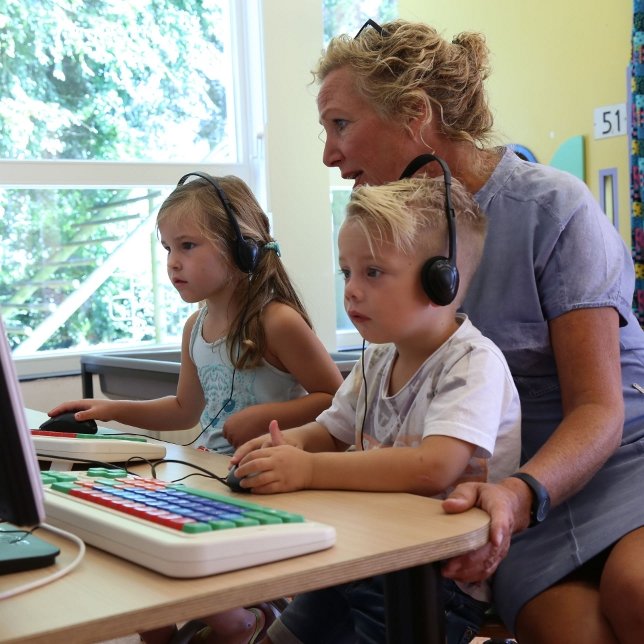 leerkracht met twee kinderen computer-instructies gevende
